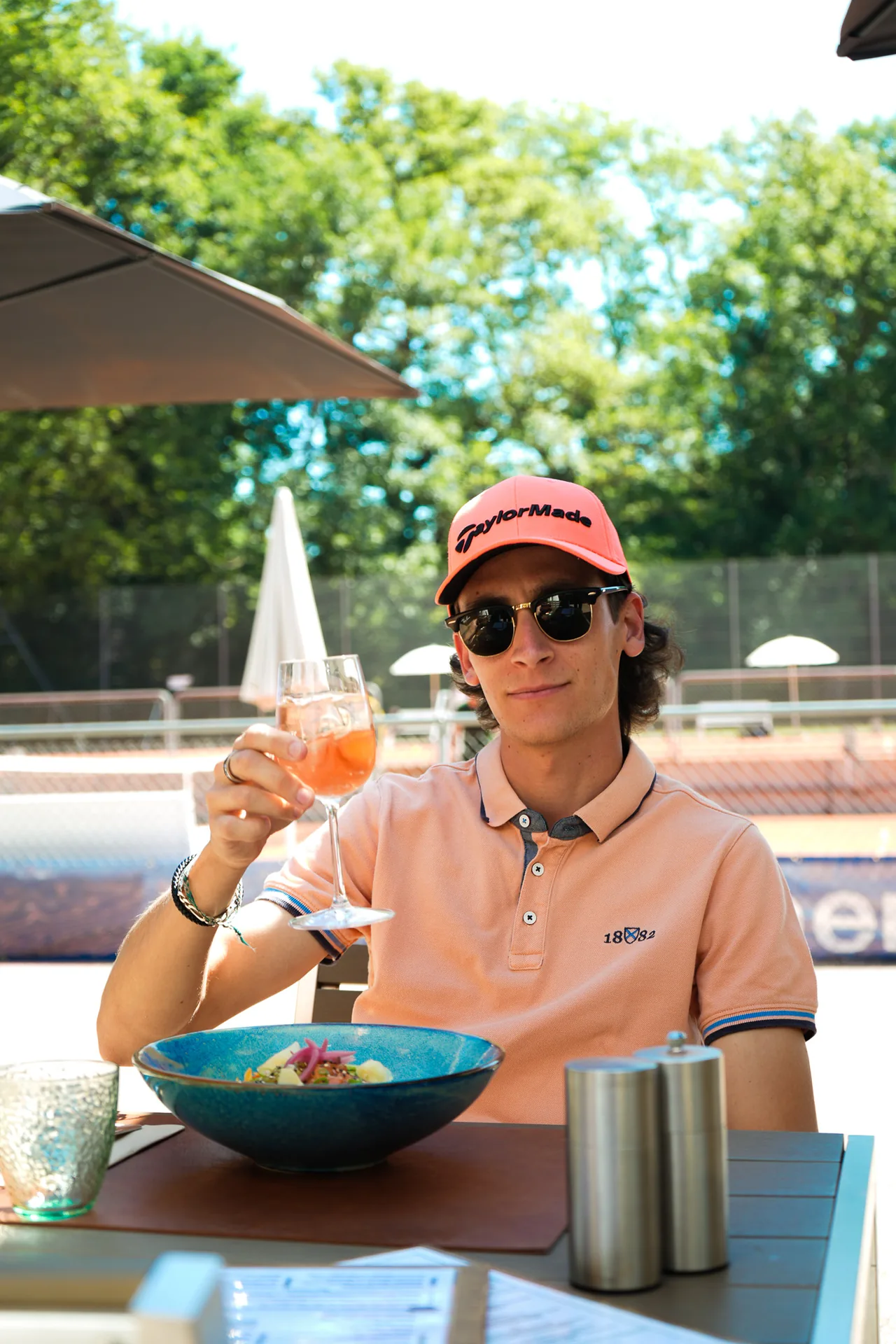 Client levant son verre en terrasse chez Open Café