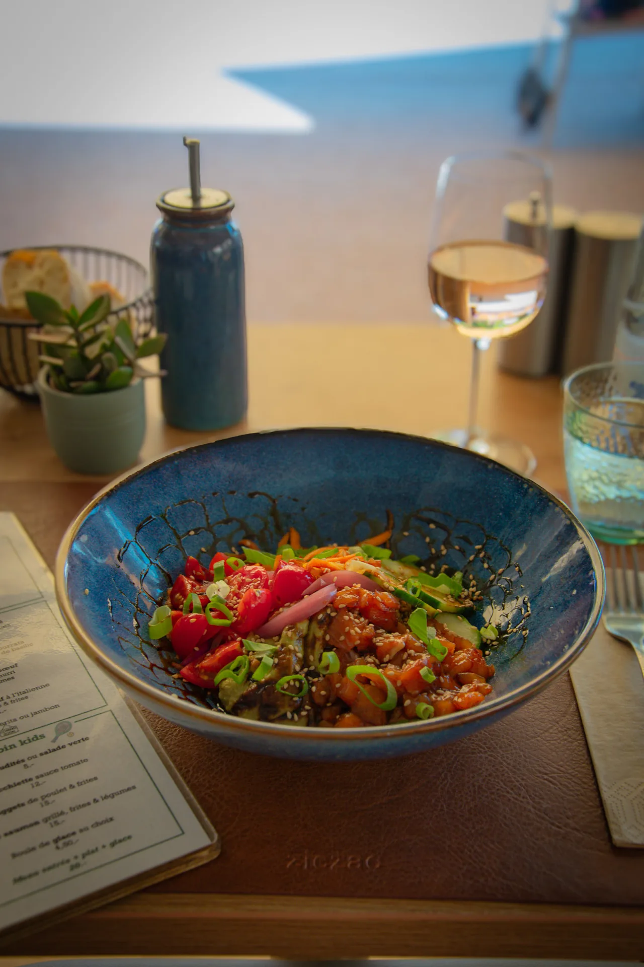 Poke bowl et verre de vin servis en salle chez Open Café
